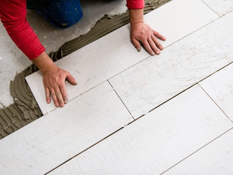 worker installing the ceramic wood effect tiles on the floor